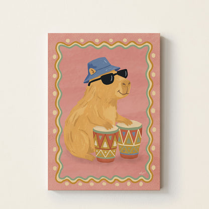 Capybara drum poster featuring a capybara wearing sunglasses and a blue bucket hat playing colorful drums on a pink background.