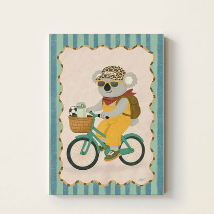 Hand-drawn koala wearing sunglasses and a backpack while riding a vintage bicycle with a picnic basket and soccer ball, whimsical adventure wall art for kids' bedrooms, nurseries, and playrooms.