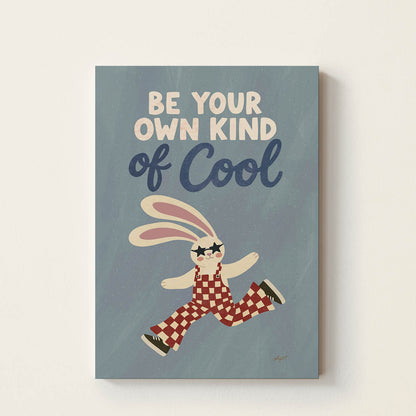 Hand-drawn bunny wearing star-shaped sunglasses and retro checkered overalls beneath the inspirational phrase "Be Your Own Kind of Cool", whimsical kids wall art for nurseries, bedrooms, playrooms, and classrooms.