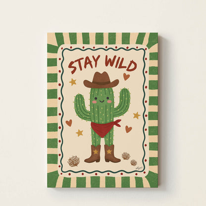Hand-drawn smiling cactus wearing a cowboy hat, boots, and a bandana with the words "Stay Wild", retro-inspired desert wall art for nurseries, bedrooms, playrooms, and children's rooms.