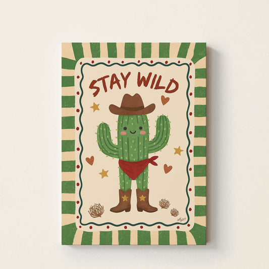 Hand-drawn smiling cactus wearing a cowboy hat, boots, and a bandana with the words "Stay Wild", retro-inspired desert wall art for nurseries, bedrooms, playrooms, and children's rooms.